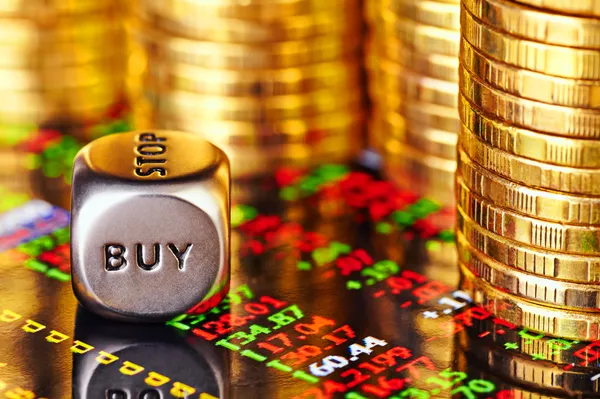 Financiële grafiek, gouden munten en dobbelstenen kubus met het woord kopen. — Stockfoto