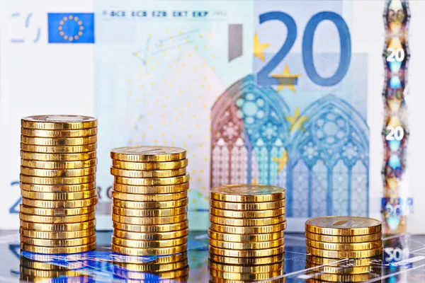 Stacks de tendência descendente de moedas de ouro e notas de euro como fundo — Fotografia de Stock