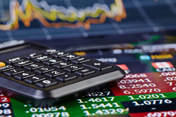 Calcolatrice e grafico finanziario come sfondo. Focus selettivo — Foto Stock