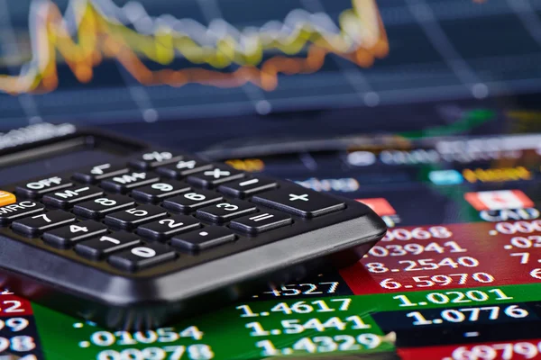 Calculadora y gráfico financiero como fondo. Enfoque selectivo — Foto de Stock