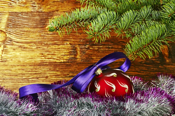 Weihnachtsdekoration. rote Kugel mit violettem Band, Tanne und — Stockfoto