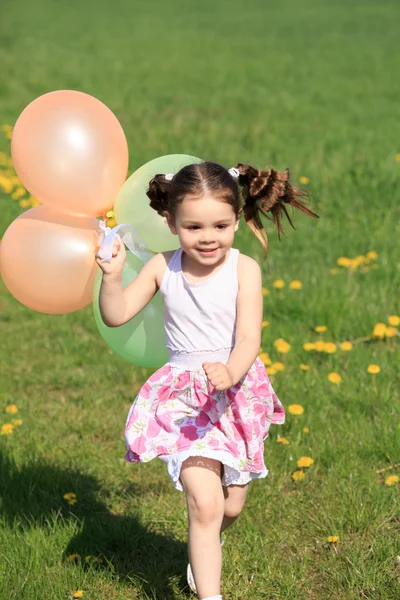 Παιδί που παίζει με μπαλόνια Εικόνα Αρχείου