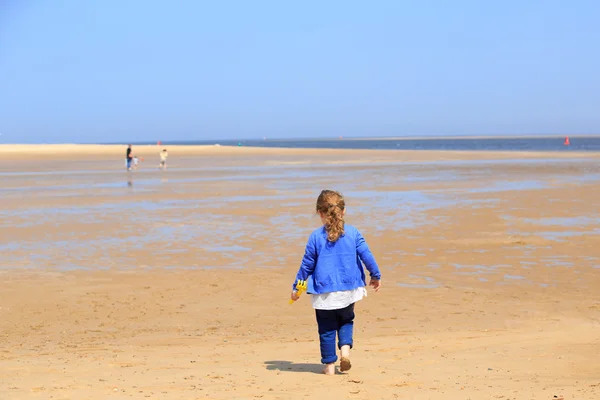 Young girl walking on a sandy beach — Stock Photo, Image