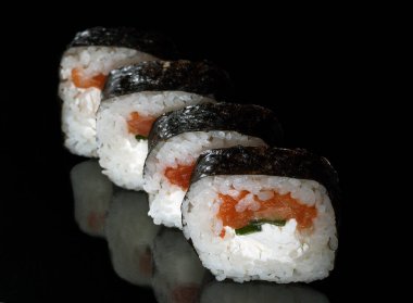 Siyah arka planda somon ve krem peynirli geleneksel suşi..