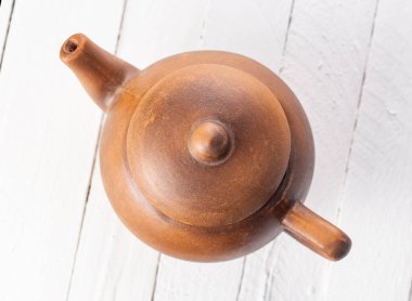 Beyaz zemin üzerinde kil çaydanlık. Üst Manzara. Yakın plan...