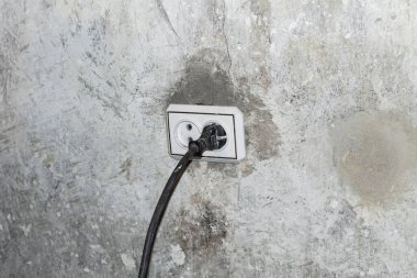 Sıva ya da alçı duvarda elektrik prizi var. İç mekan, ekipman ve teknoloji hakkında soyut dokulu arka plan.