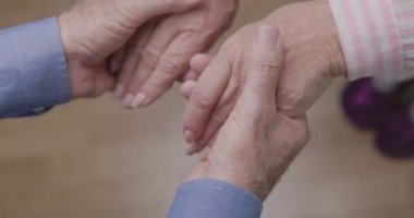 Yetişkin çiftlerin el ele tutuşması, şefkatli kocaların yaşlı karısına destek olması ve onu teselli etmesi. Evlilikte empati, anlayış ve güvenilir ilişki