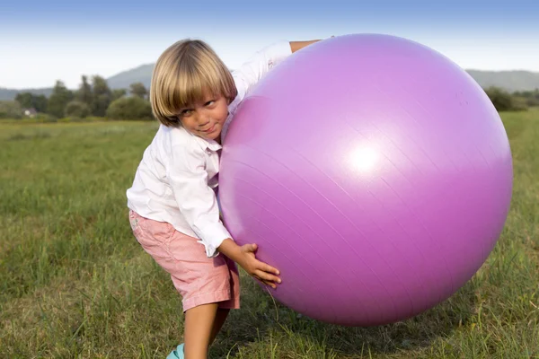 Jeune garçon jouant avec une grosse balle — Photo