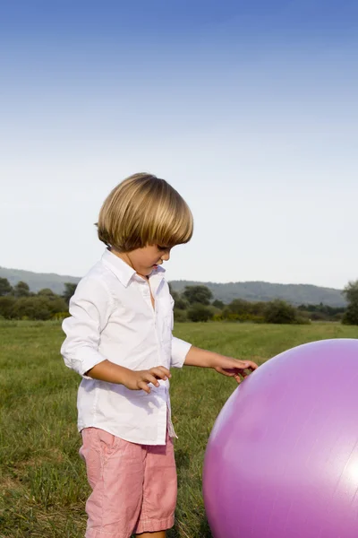 Jeune garçon jouant avec une grosse balle — Photo