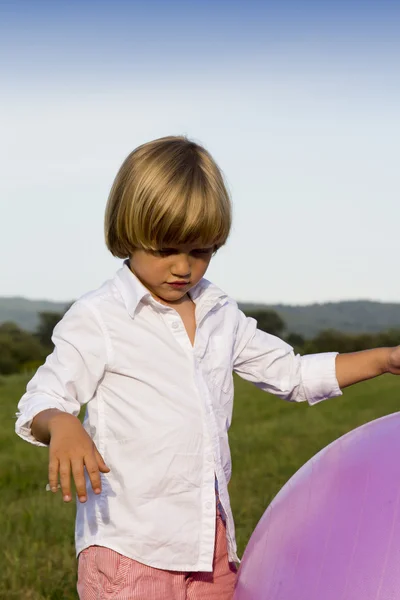 Jeune garçon jouant avec une grosse balle — Photo