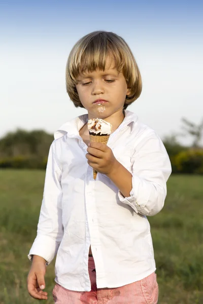 Giovane ragazzo mangiare un gustoso gelato — Foto Stock