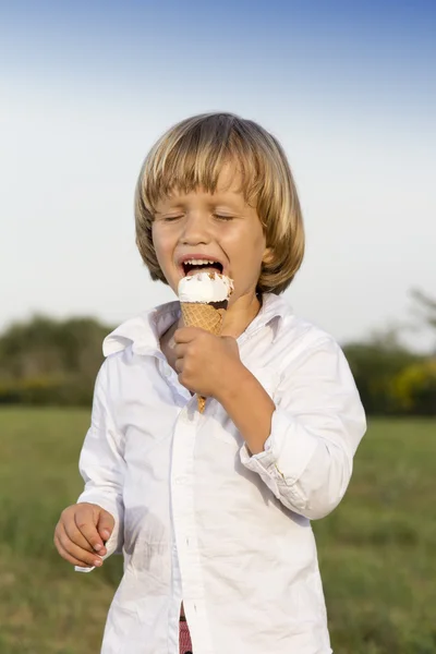 Giovane ragazzo mangiare un gustoso gelato — Foto Stock