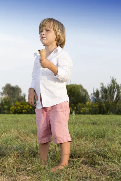 Giovane ragazzo mangiare un gustoso gelato — Foto Stock