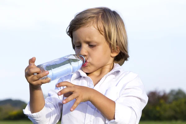 Menino bebendo água ao ar livre Imagens Royalty-Free