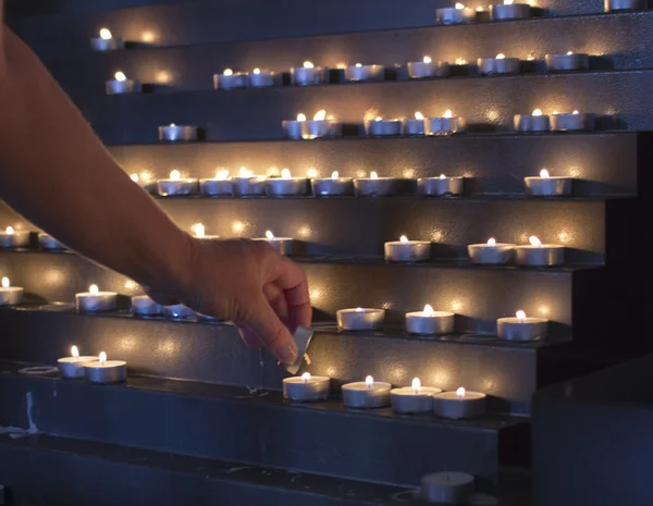 Lighting candles in a church — Stock Photo, Image