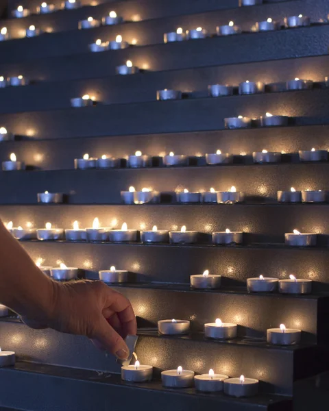 Lighting candles in a church Stock Photo
