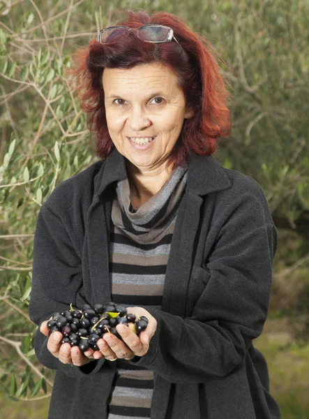 Femme mignonne montrant des olives — Photo