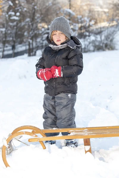 Giovane ragazzo sta giocando nella neve — Foto Stock