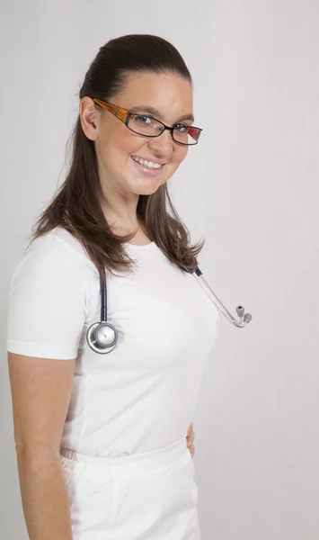 Medico sorridente femminile con uno stetoscopio — Foto Stock