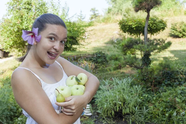 Roztomilá dívka drží zelených jablek a hrušek — Stock fotografie