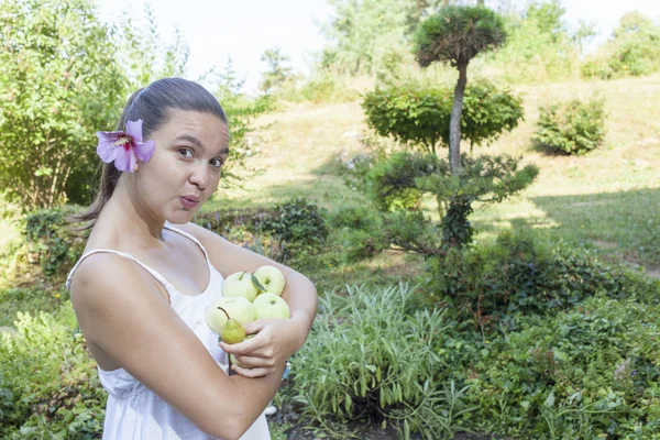 Linda chica sosteniendo manzanas verdes y peras — Foto de Stock