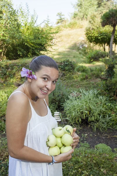 Leuk meisje bedrijf groene appels — Stockfoto