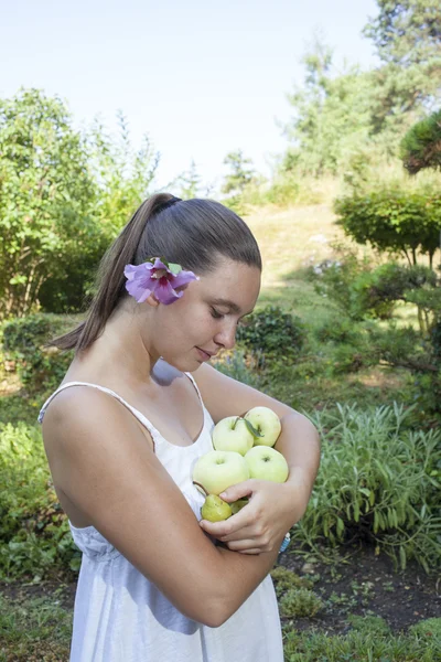 Söt flicka håller gröna äpplen och päron — Stockfoto