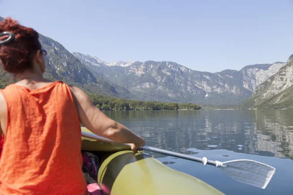 Женское весло на спокойном горном озере — стоковое фото