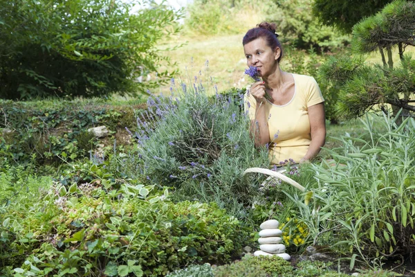 Cute female gardener smelling fresh lavender — Stock Photo, Image