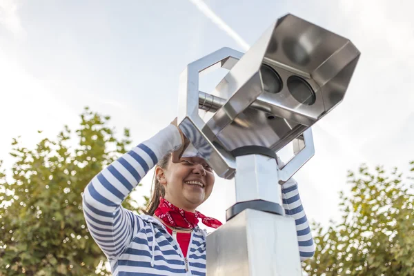 Jonge lachende vrouw met munt geëxploiteerd verrekijkers — Stockfoto