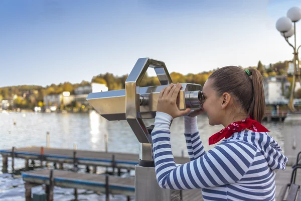 Young smiling woman using coin operated binoculars — Stock Photo, Image