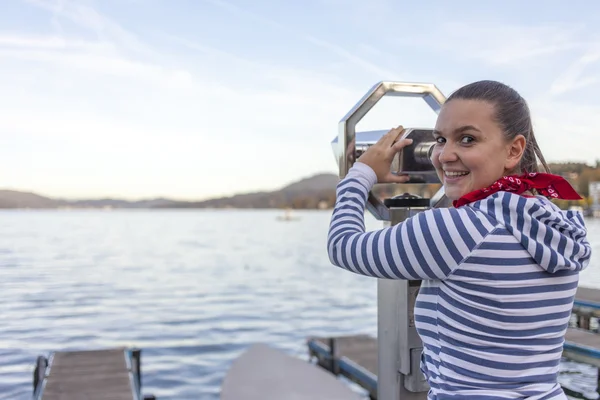 Young smiling woman using coin operated binoculars — Stock Photo, Image