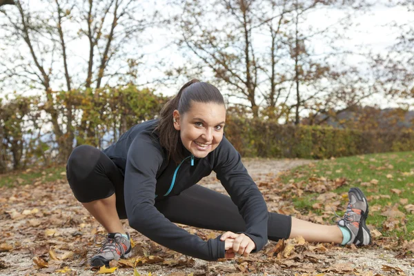 Hermosa joven mujer estirándose en el parque — Foto de Stock