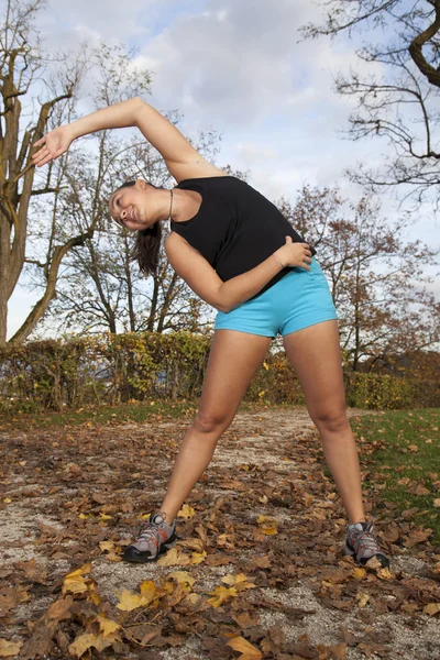 Belle jeune femme qui s'étire dans le parc — Photo