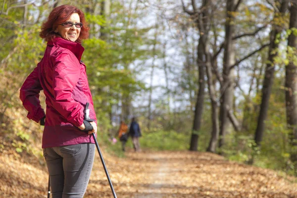 Sportive cute woman Nordic walking autumn cross country — Stock Photo, Image