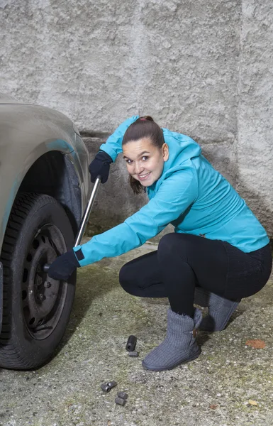 Bella ragazza che sostituisce pneumatico auto — Foto Stock