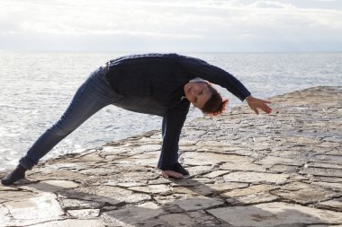 yoga yapmak deniz kenarında orta yaşlı kadın