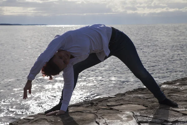 Mulher de meia idade à beira-mar realizando Yoga — Fotografia de Stock