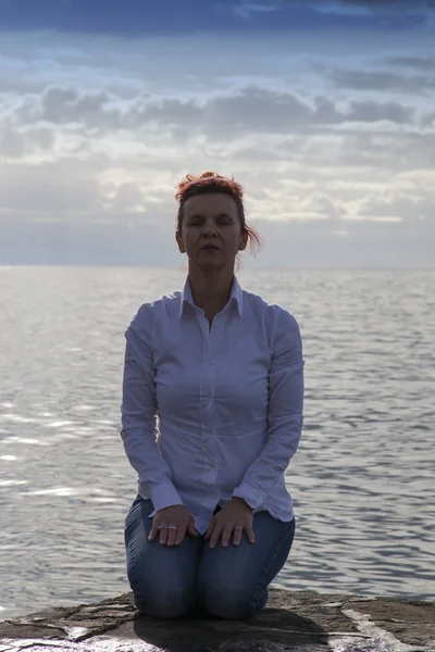 Femme d'âge moyen au bord de la mer exécutant Yoga — Photo
