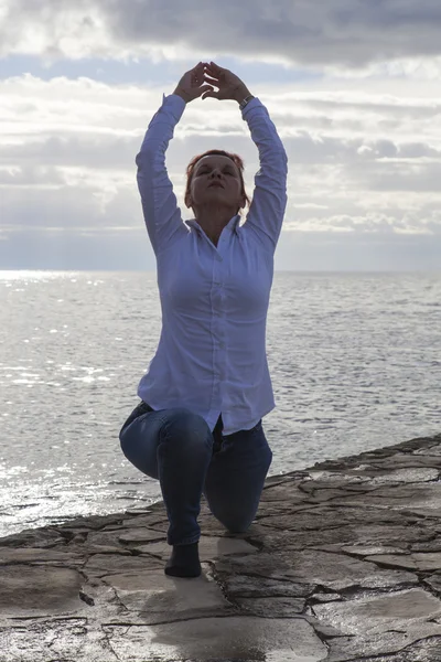Donna di mezza età al mare che esegue Yoga — Foto Stock