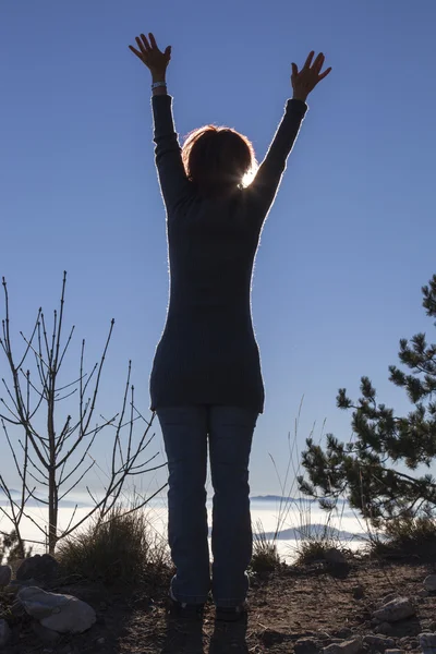 Silhouette einer Frau, die mit der Sonne im Rücken Yoga macht — Stockfoto