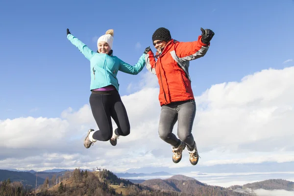 Zwei glückliche Frauen, die freudig ins Freie springen — Stockfoto