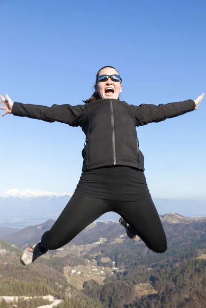 Jóvenes mujeres deportivas saltando alegremente en las montañas — Foto de Stock