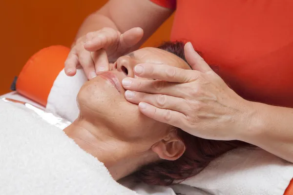 Mulher bonito recebe massagem facial profissional, drenagem linfática Fotos De Bancos De Imagens