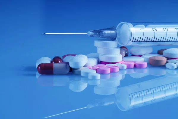 Plastic syringe and pills — Stock Photo, Image