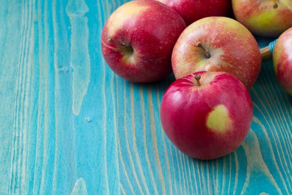 Red apples on wooden table — Stock Photo, Image