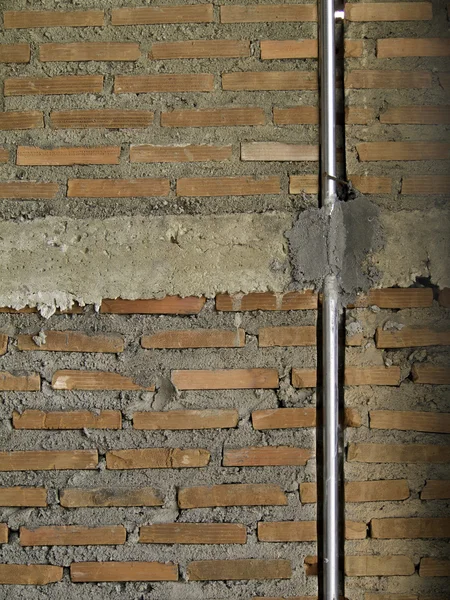 Brick wall with metal pipe. — Stock Photo, Image