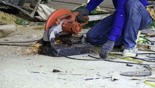 Lavoratore nel taglio di indumenti da lavoro barra di rinforzo metallico — Foto Stock