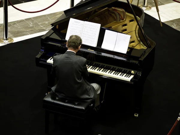 Senior man playing on a grand piano — Stock Photo, Image