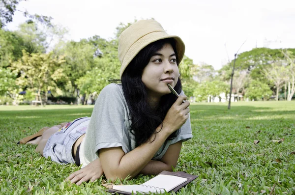 Mujer pensando duro estudiando fuera —  Fotos de Stock